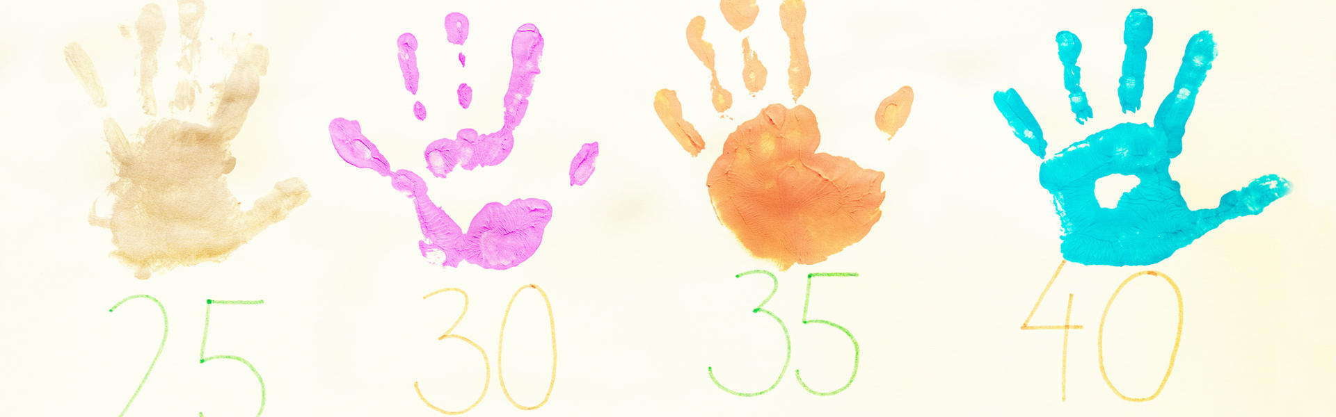 Kuvassa painettuja eri värisiä lasten kädenjäkiä ja numeroita.