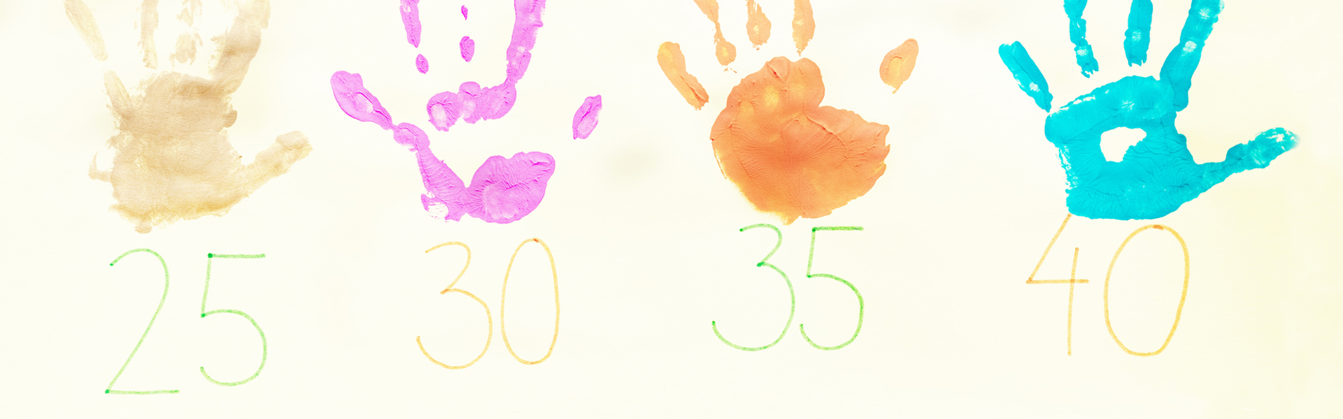 Kuvassa painettuja eri värisiä lasten kädenjäkiä ja numeroita.