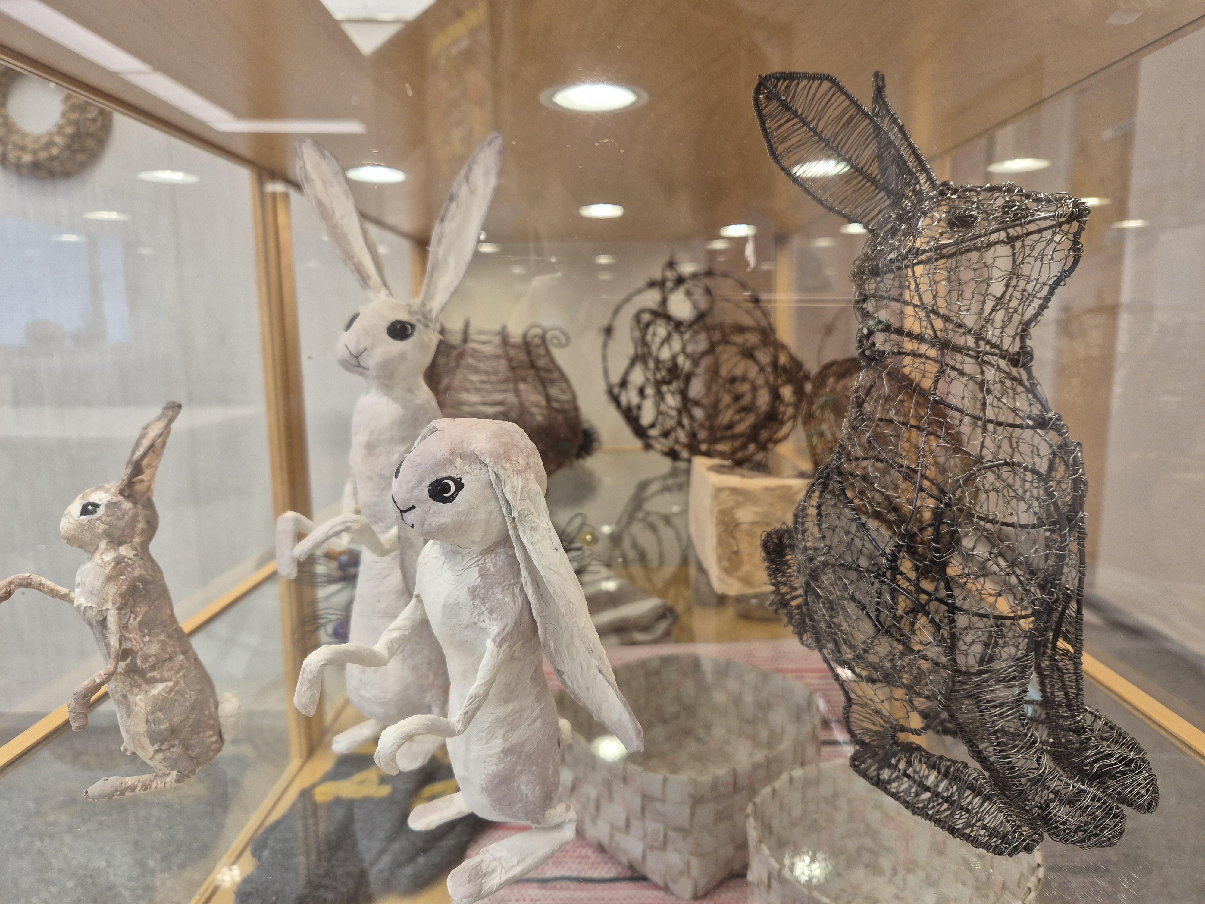 Auli Niinimäen rautalankateoksia kirjaston näyttelyssä.